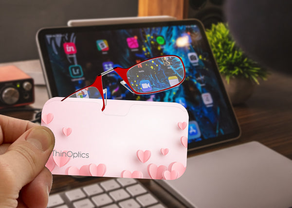 Red Frames peeking out of a Pink Hearts Universal Pod Case being held up to a screen