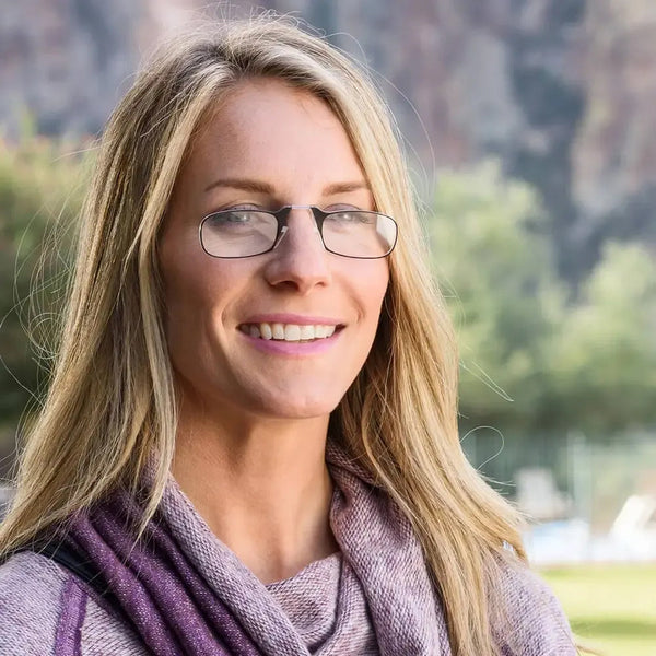 Smiling blonde woman outdoors, wearing ThinOptics Readers